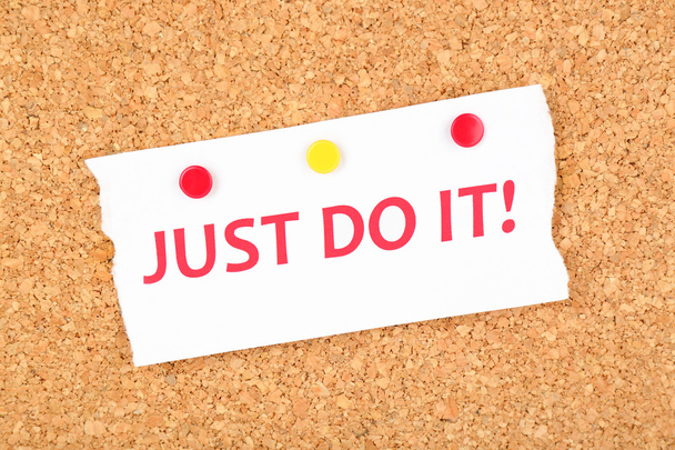 Motivating paper sheet with inscription "Just do it" on wooden background - Foto, afbeelding