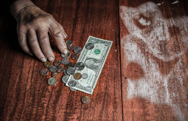 Stará žena s velmi malými penězi. Chudoba. Důchodce s dolarovou bankovkou a mincemi v rukou. Hospodářství a krize ve světě. - Fotografie, Obrázek