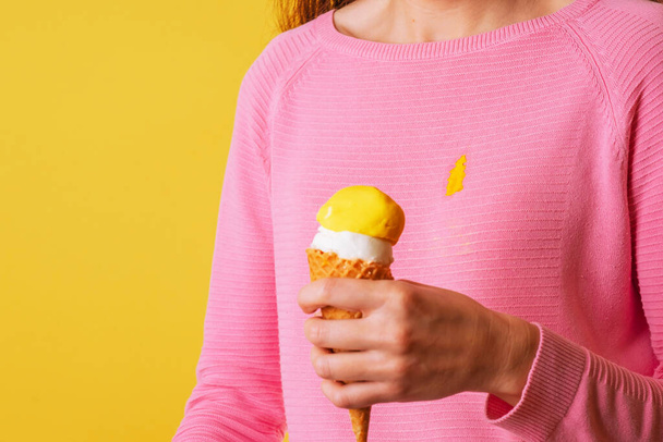 La fille portant une blouse tachée tenant de la crème glacée. Verser de la glace sur les vêtements. Photo de haute qualité - Photo, image