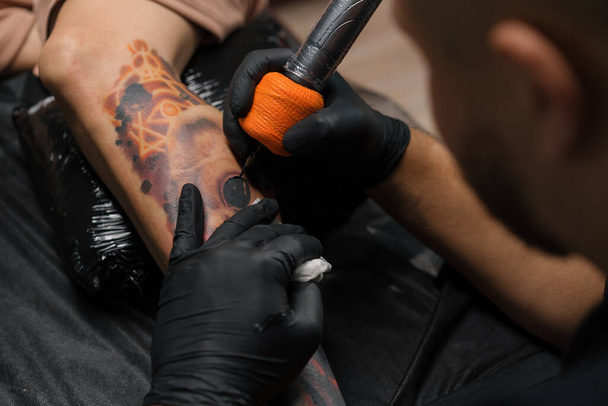 Primer plano: proceso de tatuar a una mujer en su pierna. Hombre tatuaje artista hacer un tatuaje - Foto, Imagen