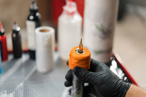 Tattoo artist collects tattoo washing machine. Tattoo needles - Foto, Imagen