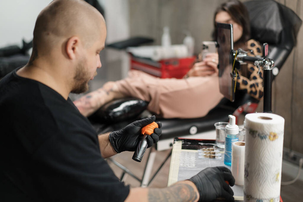 Tattoo artist collects tattoo washing machine. Tattoo needles - Photo, Image