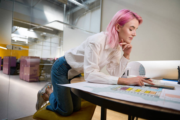 Profi tervező rózsaszín haj ül az asztalnál, miközben dolgozik építészeti projektek coworking - Fotó, kép