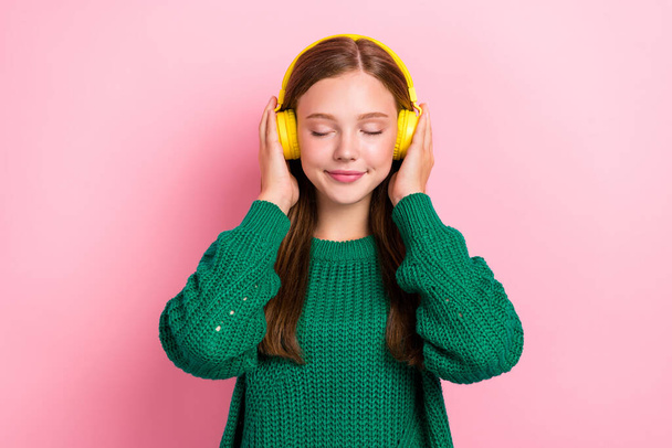 Closeup portrait photo of young dreamy relaxed girl closed eyes listening music jazz chilling pause break hold earphones isolated on pink color background. - 写真・画像