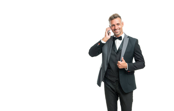 happy man in tuxedo speak on phone isolated on white background. - 写真・画像