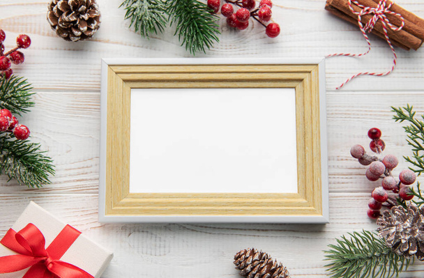 Vánoční kompozice. Fotorámeček, dekorace, jedlové větve na bílém dřevěném pozadí. Vánoce, zima, novoroční koncept. Flat lay, top view, copy spac - Fotografie, Obrázek
