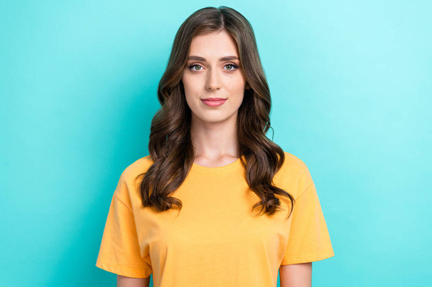 Photo of nice positive gorgeous girl with wavy hairdo dressed yellow t-shirt look at camera isolated on turquoise color background. - Foto, afbeelding