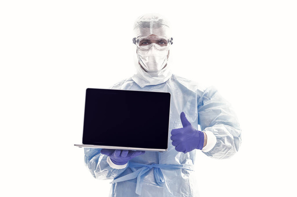 medical worker man in protective costume isolated on white keep safe of covid19 sars virus pandemic working from home on laptop online, copy space, coronavirus statistics. - Фото, зображення