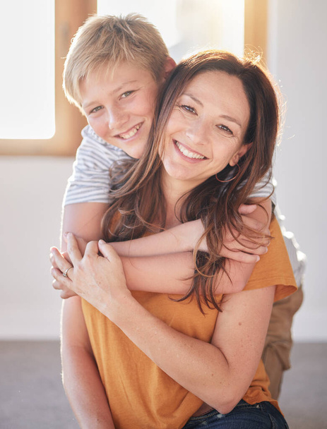 Mother, hug and kid in a family home together with happiness, bonding and parent care. Portrait of a mom and child in a house with love and happy child care smiling and hugging in a living room. - Photo, image