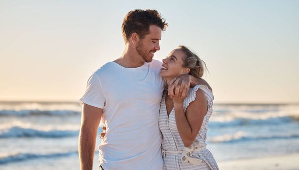 Sonnenuntergang, Liebe und Sommer mit einem Paar, das sich im gemeinsamen Urlaub am Strand oder Meer umarmt. Glücklich, lächelnd und romantisch mit Mann und Frau, die sich im Urlaub oder Urlaub auf See verbinden. - Foto, Bild