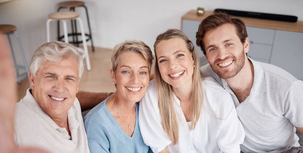 Selfie, parents and young couple in the living room of their house for love, smile and happy during a visit. Happiness, content and portrait of a senior man and woman with adult children for a photo. - Photo, image