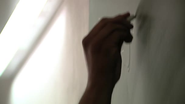 Ruka muže učitele psaní na zelené tabuli během výuky pro vězně v argentinské věznici. Zavřít.   - Záběry, video