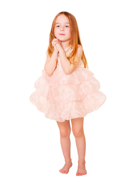 Pembe elbiseli küçük kız beyazı soyutluyor. Stüdyoda bir çocuğun portresi.. - Fotoğraf, Görsel