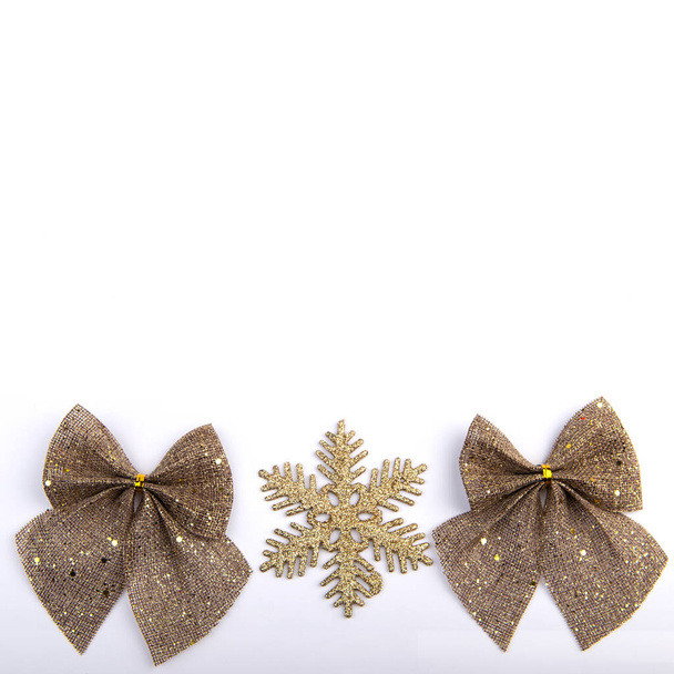 Fiocchi di iuta con glitter oro e fiocco di neve su sfondo bianco, decorazioni natalizie - Foto, immagini