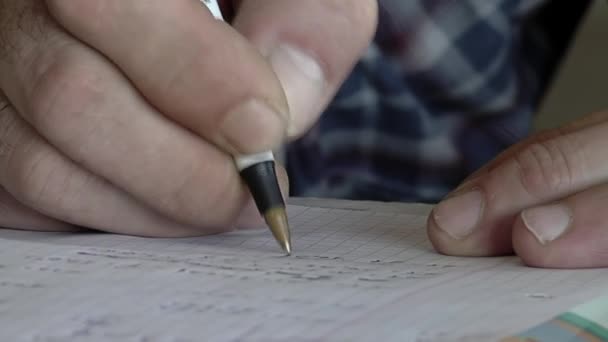 Egy rab keze, aki a jegyzetfüzetébe ír egy argentin börtön foglyainak szóló oktatási órán. Közelkép.   - Felvétel, videó