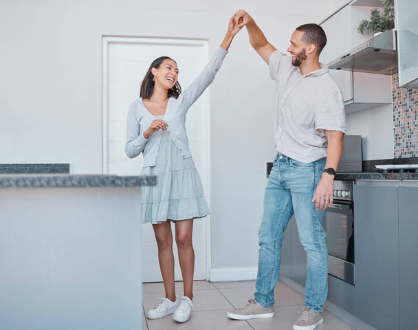 Happy couple, dancing and celebration for new home, love or marriage while together in kitchen for care, fun and energy for happiness. Man and woman in house for romantic dance and quality time. - Photo, image