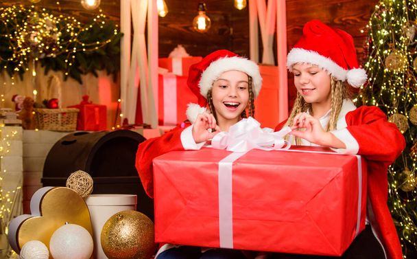 great surprise. merry christmas. happy small girls has xmas mood. new year party celebration. sisters spend family holiday together. santa children present box. winter shopping sale kid store. - Фото, зображення