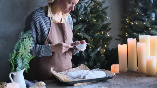 la ragazza spruzza lo zucchero a velo sullo stollen di Natale. - Filmati, video