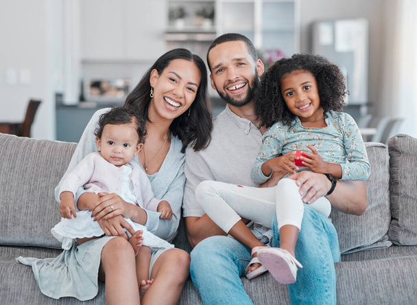 Happy, smile and portrait of a family on a sofa relaxing, bonding and sitting together in the living room. Mother, father and children resting on the couch with love, care and happiness at their home. - Foto, Bild