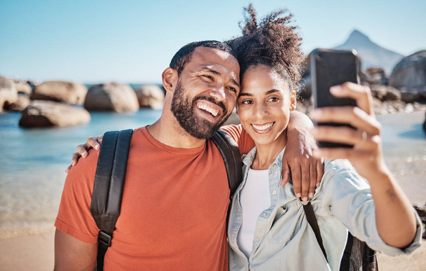 Couple, phone selfie and beach travel adventure together for social media, holiday vacation and summer in nature. Man, happy woman and hug for mobile phone photograph at ocean sea for happiness. - Photo, Image