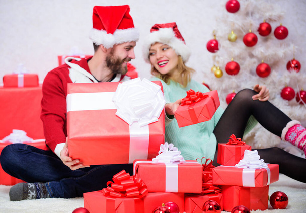 Woman and bearded man in love sit near christmas tree background. Christmas eve with darling. Love is best gift. Family married couple at home. Couple in love enjoy winter holiday celebration. - Foto, imagen