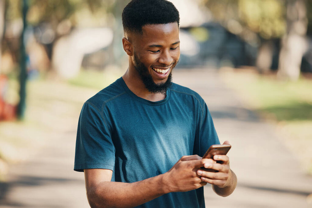 Feliz, hombre negro y teléfono inteligente en la ciudad, para la comunicación y al aire libre para las redes sociales. Hombre afroamericano, sonrisa y teléfono celular para chatear, navegar en línea y buscar internet con felicidad - Foto, imagen