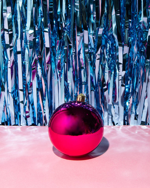 New Year party idea. Pink bauble on retro and pastel pink background. Creative Christmas concept. - Foto, afbeelding