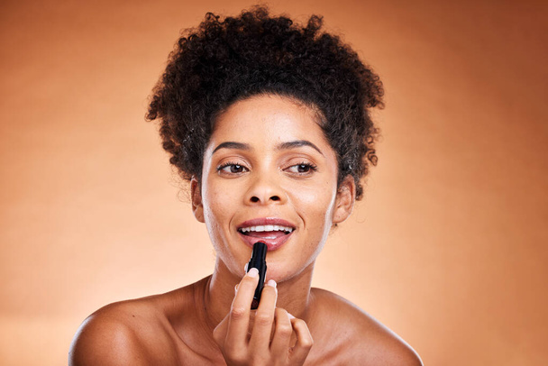 Musta nainen, afro ja kasvot hehku huulipuna studiolla taustalla aamulla grooming rutiini, itsehoitoa tai tyytyväisyyttä. Hymyä, iloa tai kauneutta malli huulikiilto, meikki kosmetiikka ja väri tuote. - Valokuva, kuva