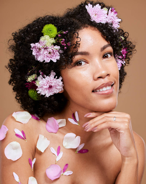 Beauty, art and black woman with flowers in hair in portrait with studio background. Nature, luxury spa and woman with flower crown, natural skincare or hair care product with sustainable ingredients. - 写真・画像