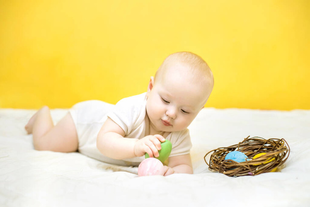 子供はイースターエッグをノックする。卵のタッピング。赤ちゃんはイースターを楽しんで - 写真・画像