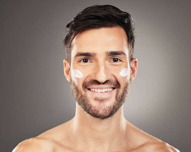 Huid, gezondheid portret van de mens met crème op het gezicht voor anti veroudering en gloeiende huid op studio-achtergrond. Schoonheids-, gezichts- en mannelijk model met luxe product voor gezonde huidbehandeling en zelfverzorging - Foto, afbeelding