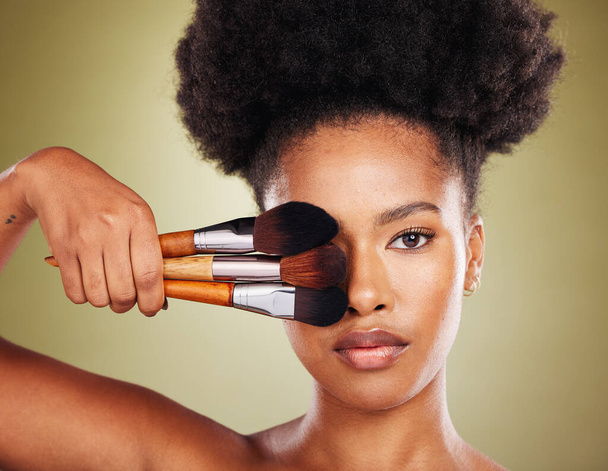 Black woman, makeup brush and beauty in studio for skincare portrait, wellness and cosmetics by backdrop. African woman, model and face with cosmetic tools, hand and powder for skin by background. - 写真・画像