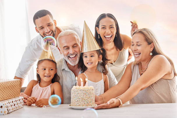 Anniversaire, fête et famille avec une fille, parents et grands-parents dans la célébration ensemble dans leur maison. Gâteau, chapeau et cadeau avec des enfants célébrant une étape importante lors d'un événement heureux dans une maison. - Photo, image