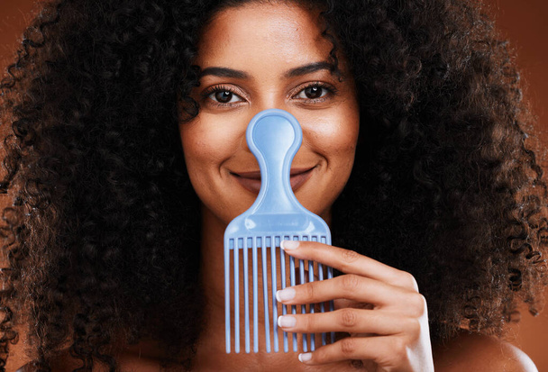 Black woman face, beauty and comb for hair care, beauty and afro with smile for happy smile in studio background. Portrait of African American female smiling for beauty hairstyle or salon treatment. - Foto, Imagem
