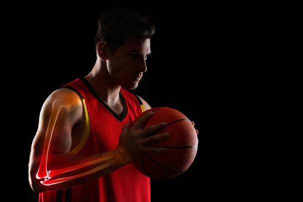 Digital composite of highlighted bones and basketball player with ball on black background - Фото, изображение