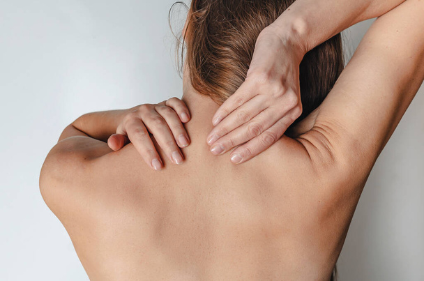 Woman holds neck muscles. Feels pain. Treatment of neuralgia - Foto, imagen