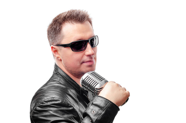 Rock singer in glasses holding a microphone in hands on white background. - 写真・画像