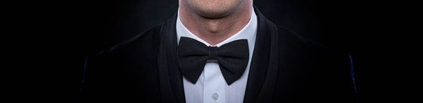 Κομψός νεαρός άνδρας με κοστούμι σε σκούρο φόντο. - Φωτογραφία, εικόνα