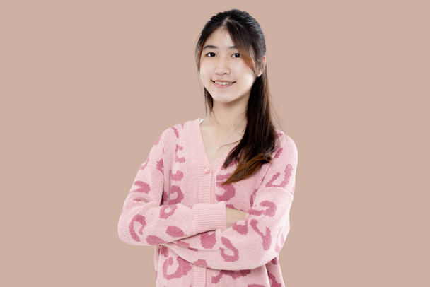 Portrait of Happy Asian ethnicity teen girl isolated on pastel brown background. - Photo, Image