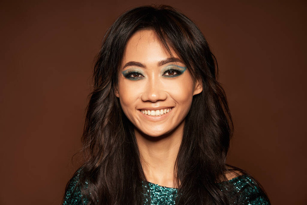Close-up portrait of beautiful asian woman with long hair smiling looking at camera over studio background. Vogue style portrait, fashion , beauty concept - Foto, afbeelding