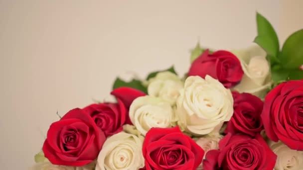 Šampaňské brýle a kytice z červených, bílých růží na bílém pozadí.  - Záběry, video