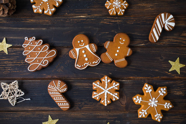 Christmas cookies of various shapes with sugar decor glaze on the wooden table, flat lay with decor - Photo, image