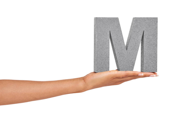 This is the letter M. A young woman holding a capital letter M isolated on a white background - Foto, afbeelding