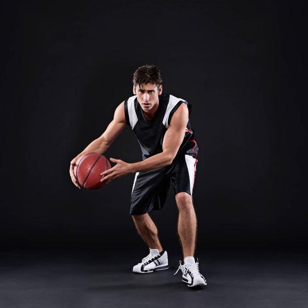 Feeling intimidated by my awesomeness yet. Full length portrait of a male basketball player in action against a black background - Foto, imagen