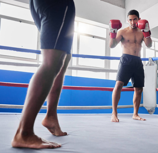 Boxing, sports and fight with a man athlete in the ring with a rival for competition in a sport club. Gym, fitness and exercise with a male fighter and coach training in a health facility together. - Fotografie, Obrázek