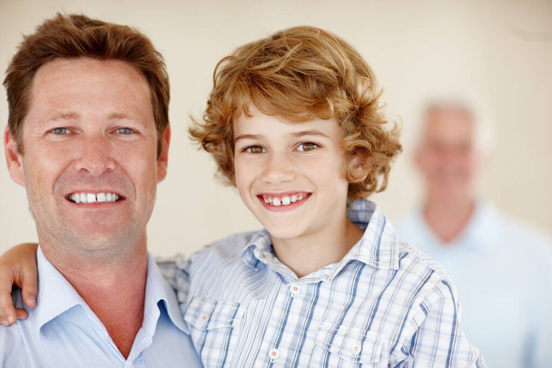 Hes his fathers son. Cropped portrait of a young boy and his father with granddad in the background - Foto, imagen