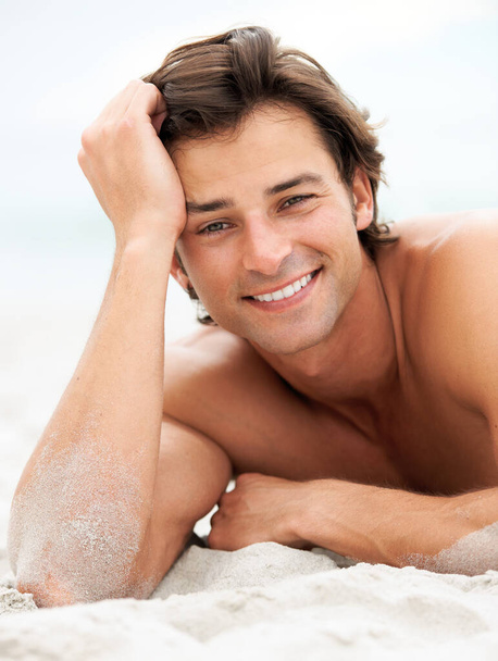 Home is where the beach is. a handsome young man enjoying a relaxing day at the beach - Foto, afbeelding