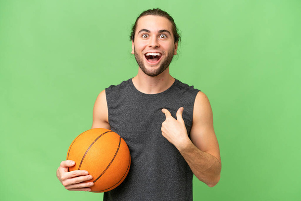 Joven jugador de baloncesto hombre sobre fondo aislado con expresión facial sorpresa - Foto, imagen