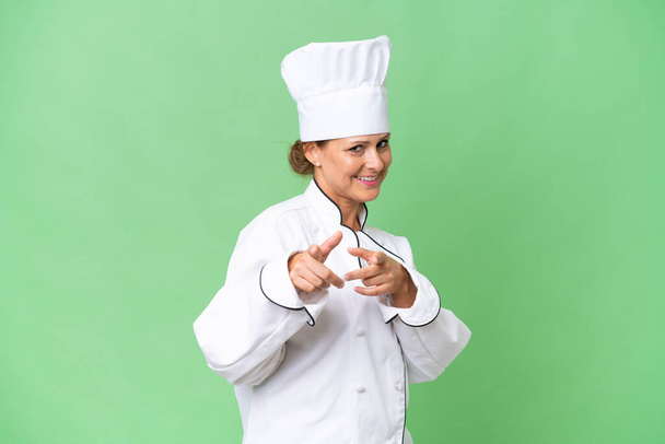 Middle-aged chef woman over isolated background pointing to the front and smiling - Photo, Image