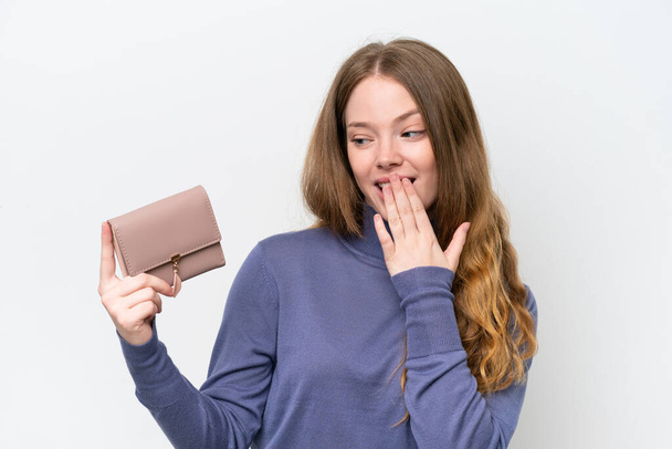 Young pretty woman holding wallet isolated on white background with surprise and shocked facial expression - Photo, Image